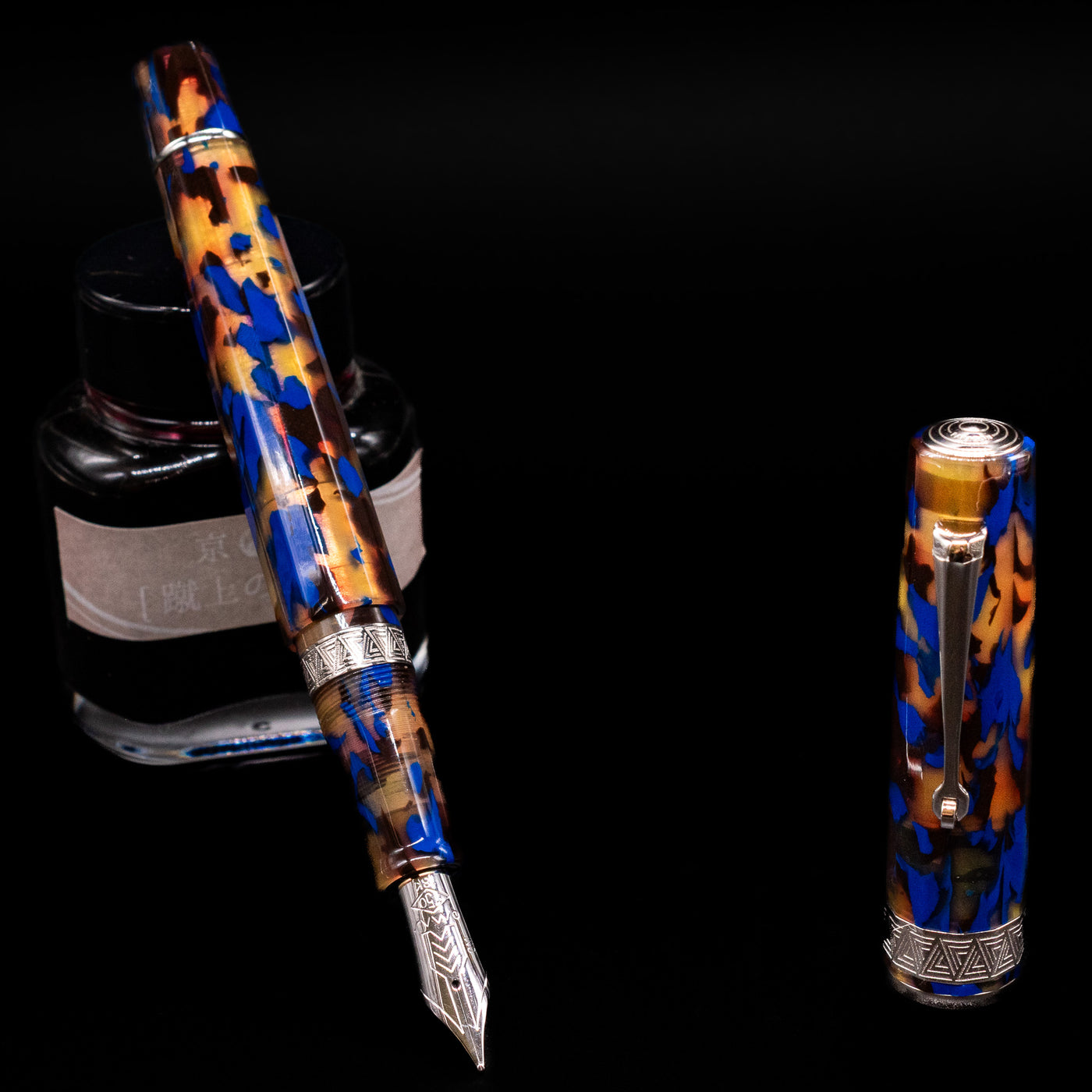 OMAS Paragon Fountain Pen - Blue Lucen leaning on an ink bottle uncapped showcasing the detailing on the nib.