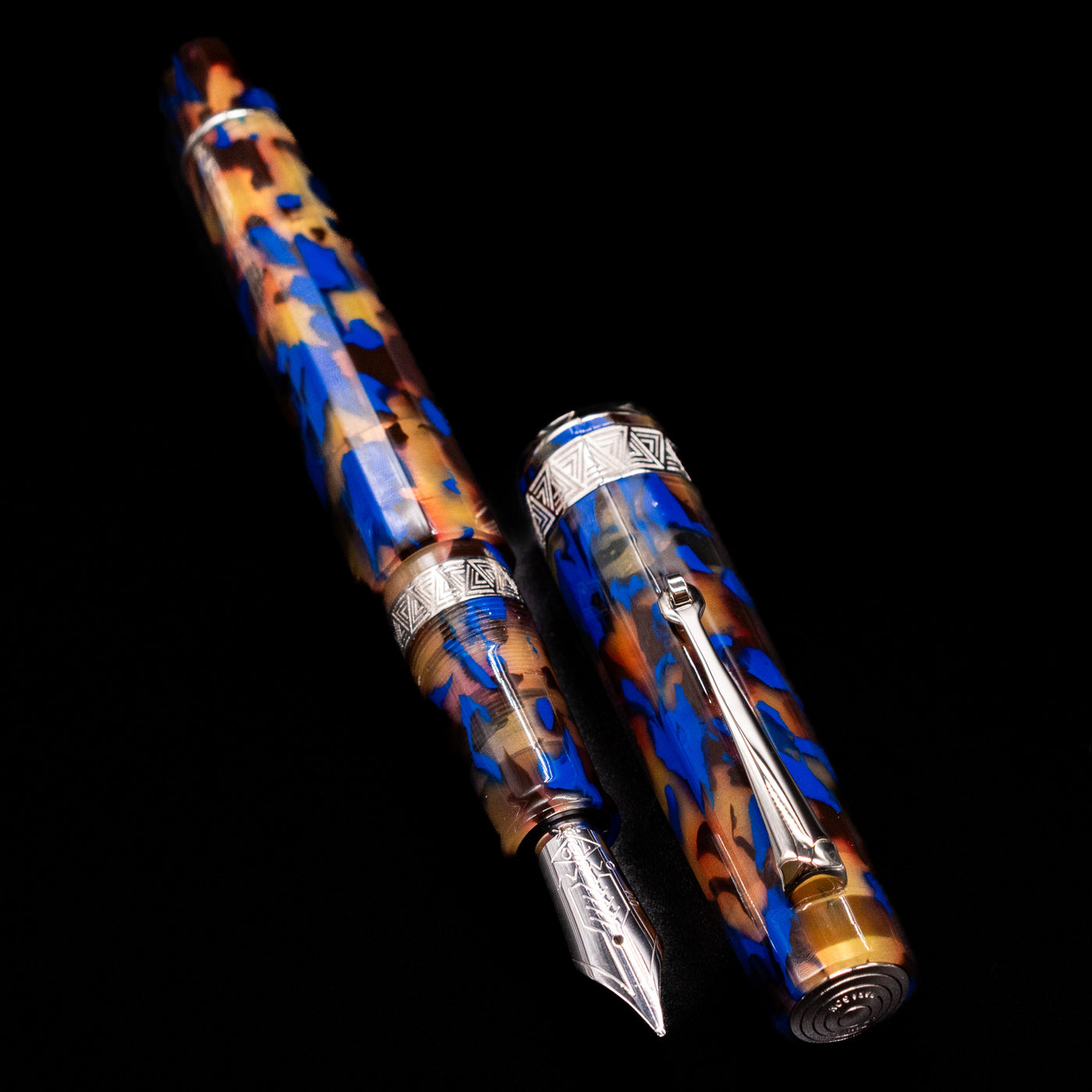 A full view of the OMAS Paragon Fountain Pen - Blue Lucen uncapped, with its cap laying next to the pen. 