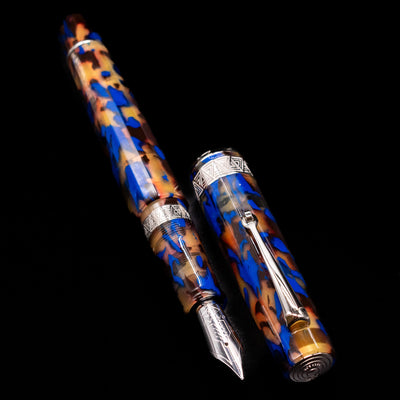 A full view of the OMAS Paragon Fountain Pen - Blue Lucen uncapped, with its cap laying next to the pen. 