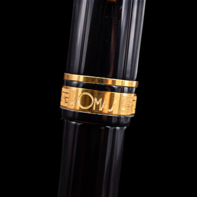 A macro shot of the center band and logo on the Omas Ogiva Fountain Pen - Nera Gold.