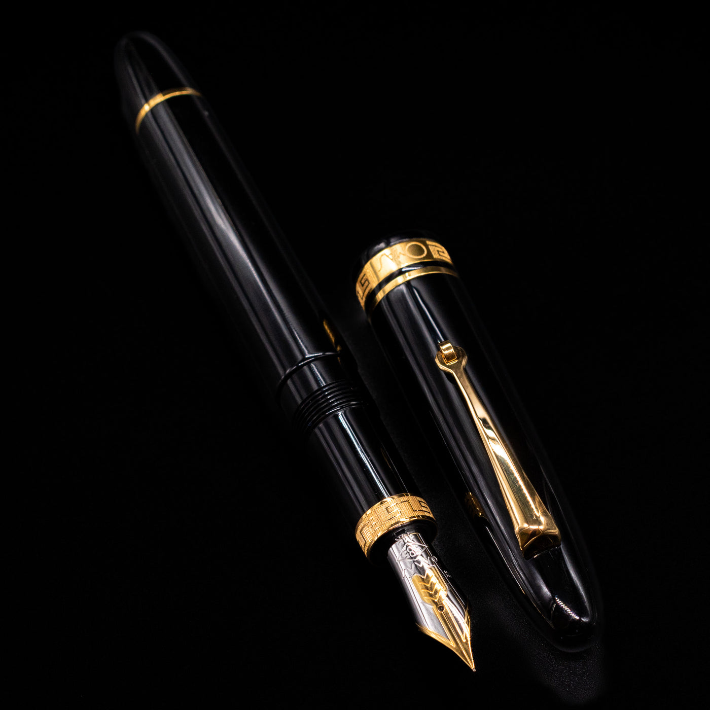  A full view of the Omas Ogiva Fountain Pen - Nera Gold uncapped, with its cap laying next to the pen. 