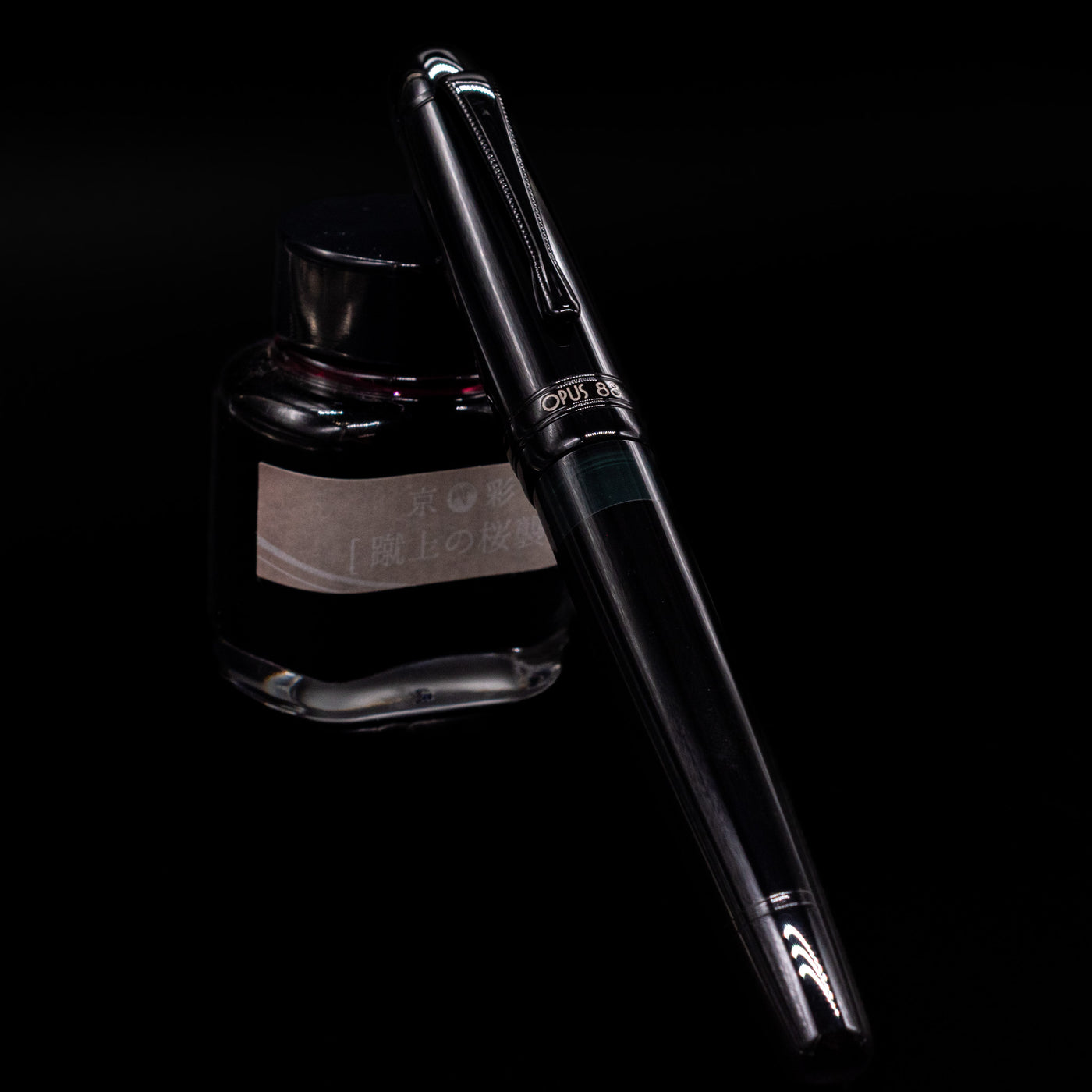 Opus 88 Jazz Solid Black Fountain Pen - Preowned capped, leaning against an ink bottle. 