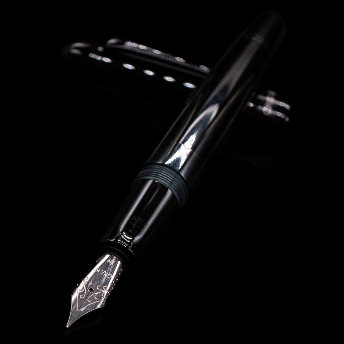 Opus 88 Jazz Solid Black Fountain Pen - Preowned laying across its own cap, crossed, with a focus on the nib.