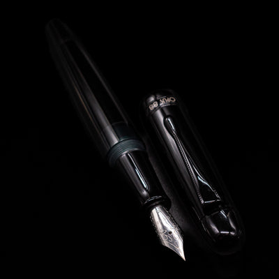 A full view of the Opus 88 Jazz Solid Black Fountain Pen - Preowned uncapped, with its cap laying next to the pen. 