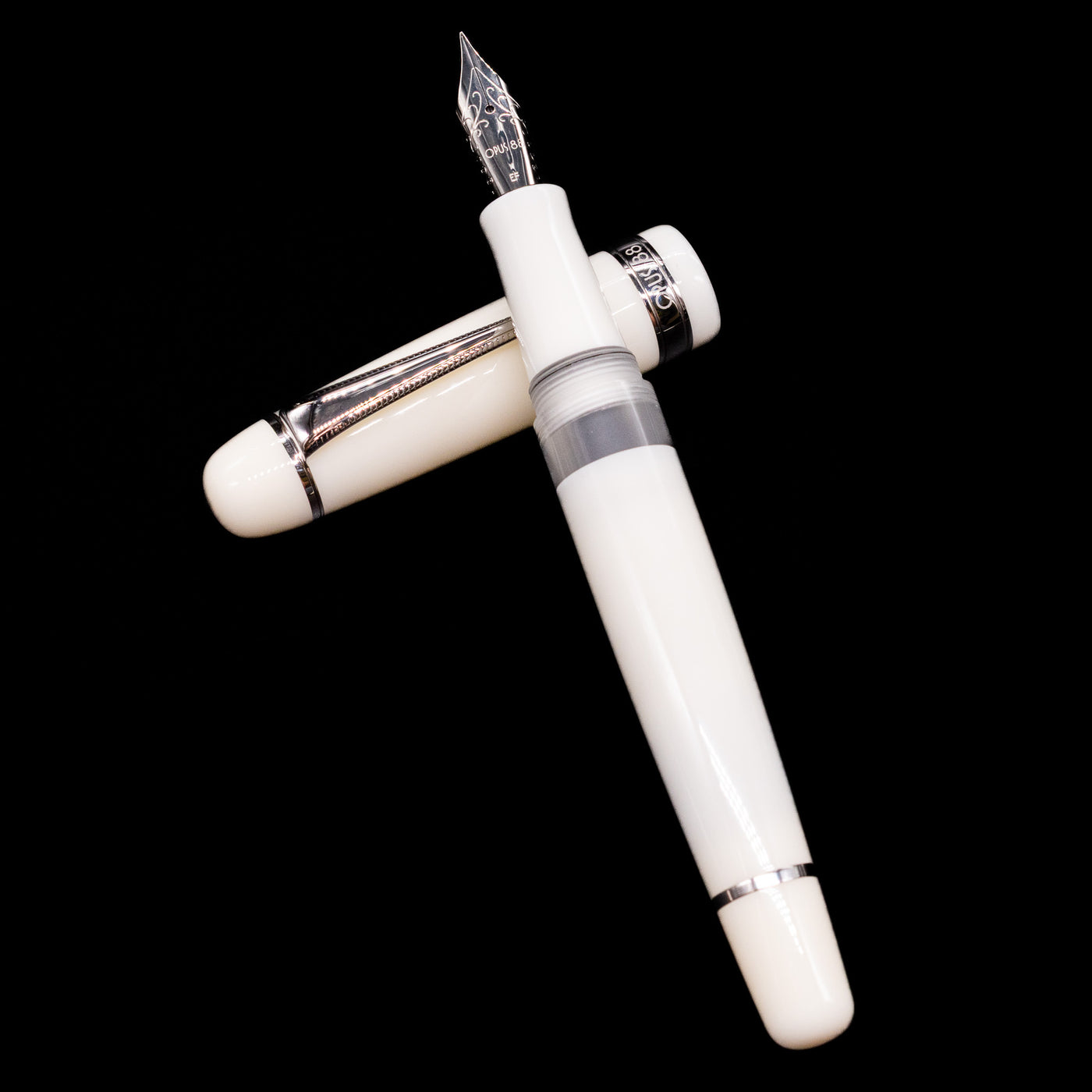 Opus 88 Jazz Solid White Fountain Pen - Preowned laying on top of its cap in a crossed position showing full view of the entire uncapped pen.