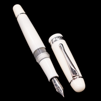 A full view of the Opus 88 Jazz Solid White Fountain Pen - Preowned uncapped, with its cap laying next to the pen. 
