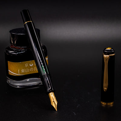 Pelikan Classic M200 black fountain pen with gold trim and stainless steel nib, shown with piston ink bottle – premium fountain pen for smooth writing