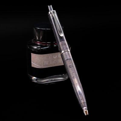 Pelikan K205 Special Edition Ballpoint Pen - Moonstone leaning against an ink bottle. 