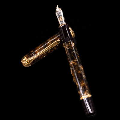 Pelikan Souverän M1000 Renaissance Brown fountain pen and cap arranged in a crossed position, showcasing the intricate marbling of the barrel and the pen’s luxurious gold-plated appointments.