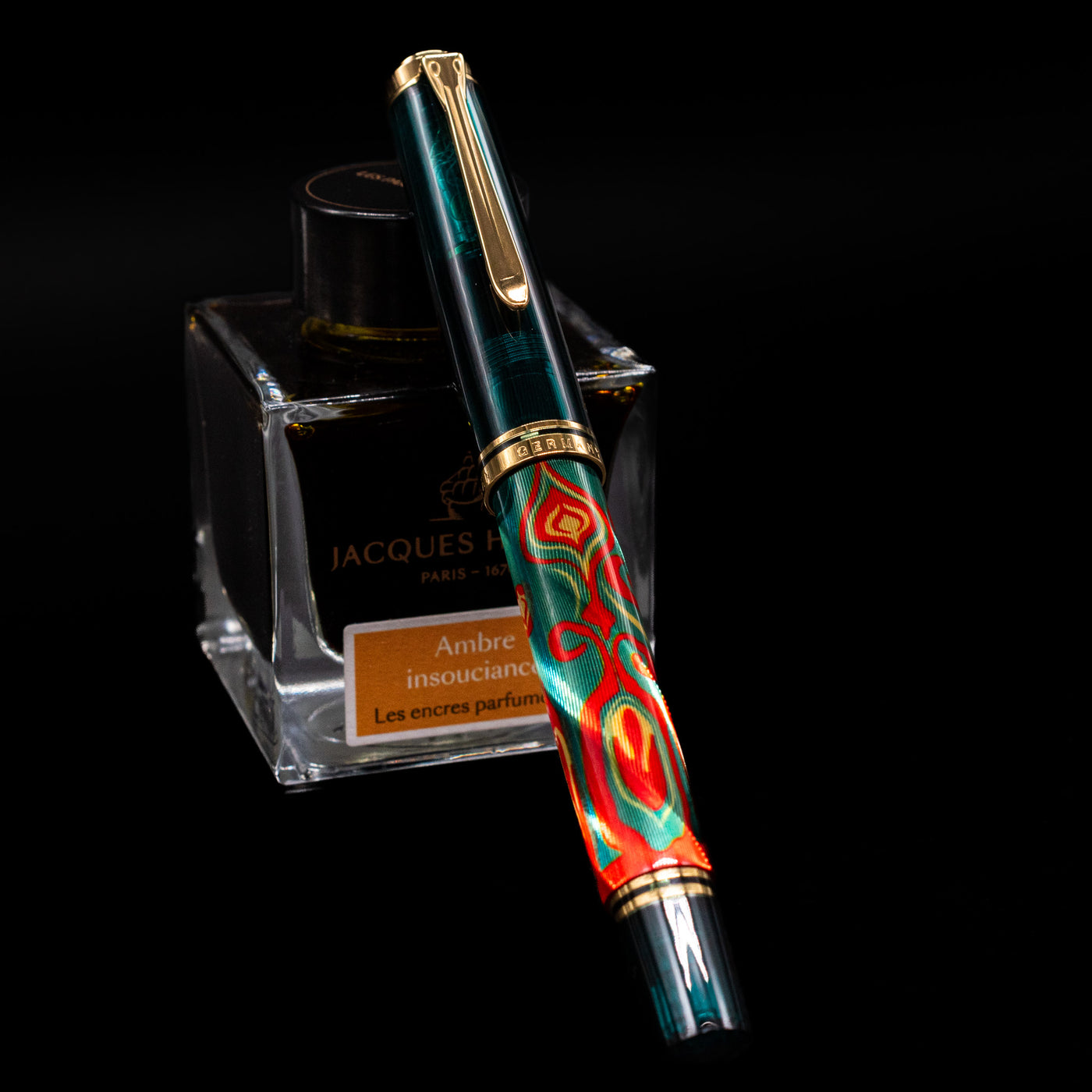 Pelikan Souveran M605 Art Collection Fountain Pen - Rudi Rother capped, leaning against an ink bottle. 