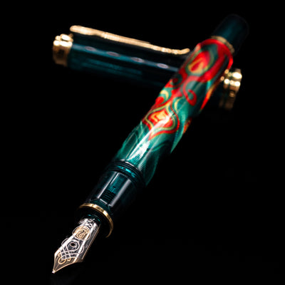 Pelikan Souveran M605 Art Collection Fountain Pen - Rudi Rother laying across its own cap, crossed, with a focus on the nib.