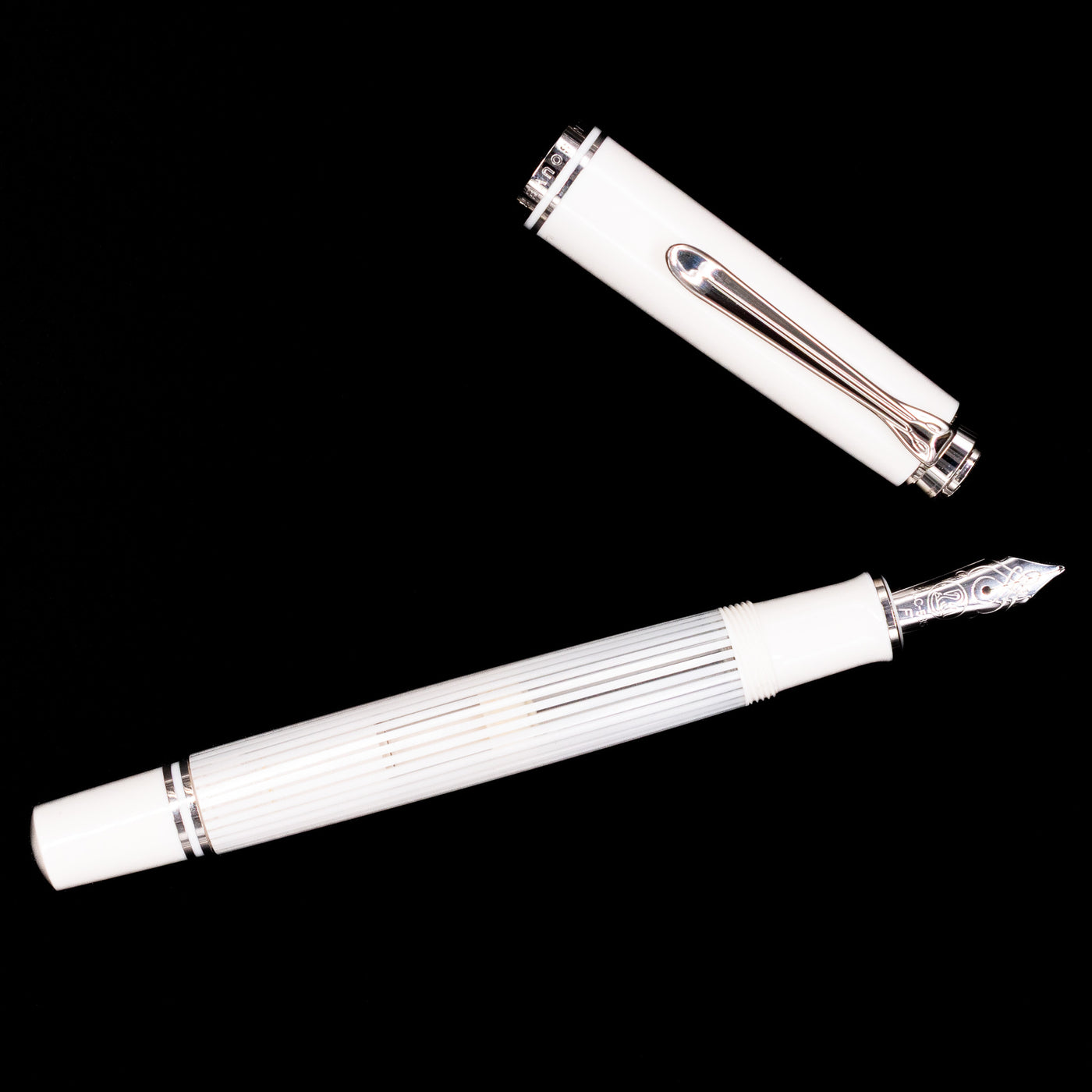 Overhead view of the Pelikan Souverän M605 White Transparent fountain pen, displaying the streamlined silhouette, bright white cap, and palladium-plated clip.
