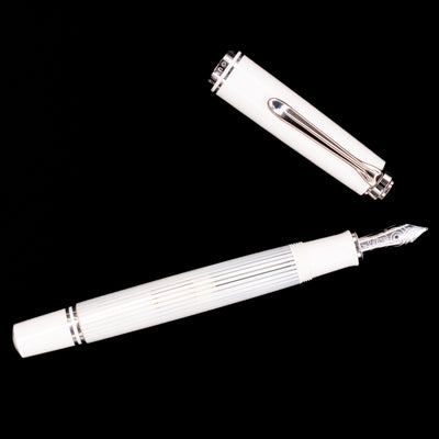 Overhead view of the Pelikan Souverän M605 White Transparent fountain pen, displaying the streamlined silhouette, bright white cap, and palladium-plated clip.