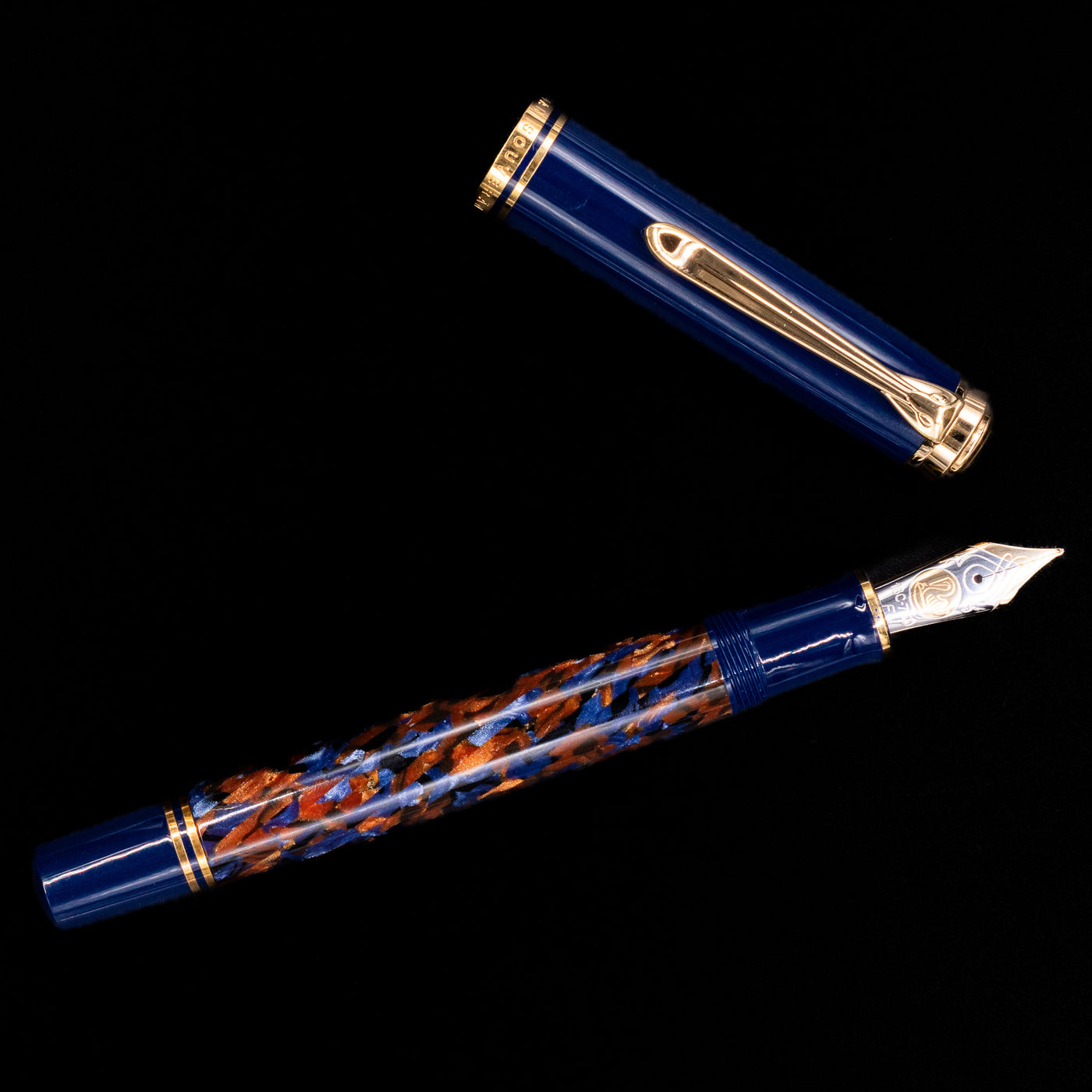 Overhead view of the preowned Pelikan Souverän M800 Stone Garden fountain pen, showcasing the balanced proportions, blue cap, and gold clip.