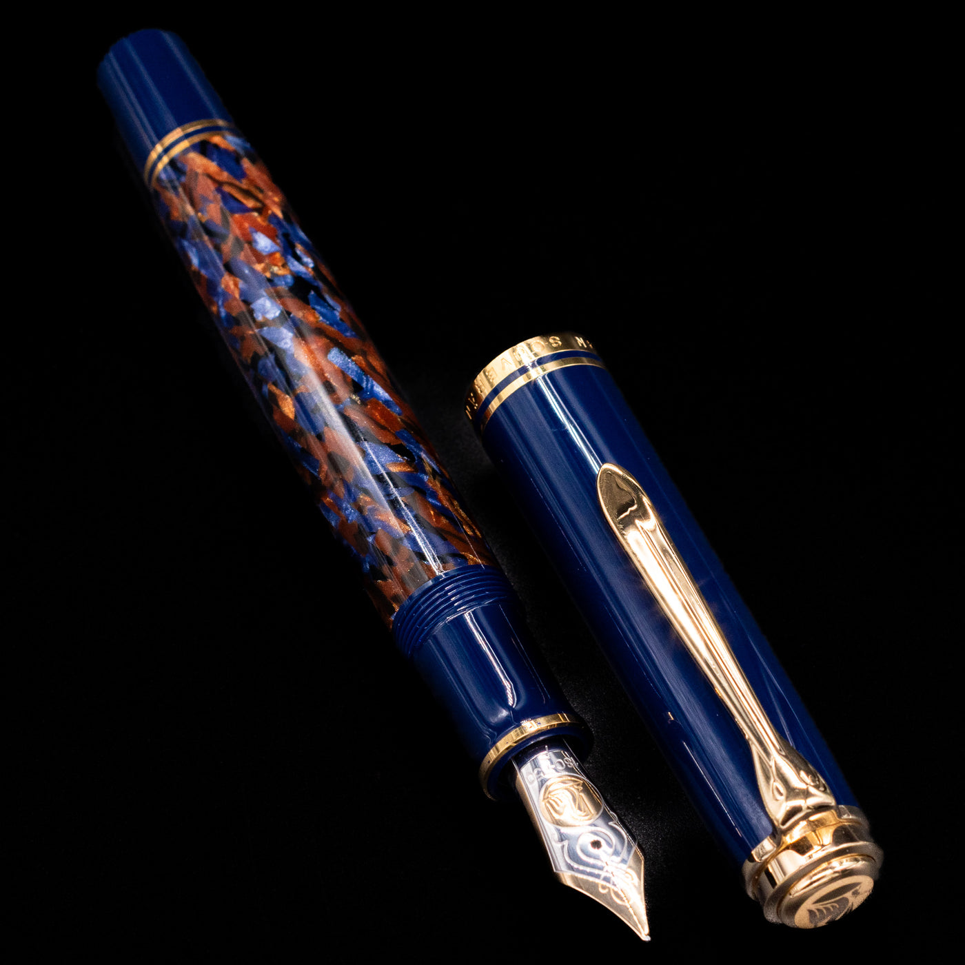 Preowned Pelikan Souverän M800 Stone Garden fountain pen displayed uncapped, showing the marbled blue barrel, dark blue cap, and gold-plated trim.