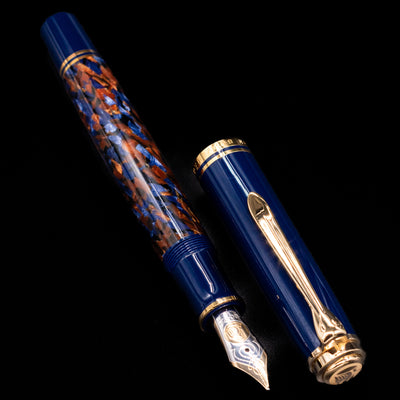 Preowned Pelikan Souverän M800 Stone Garden fountain pen displayed uncapped, showing the marbled blue barrel, dark blue cap, and gold-plated trim.