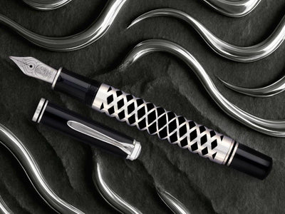 Fountain pen with decorative cap on a dark textured surface