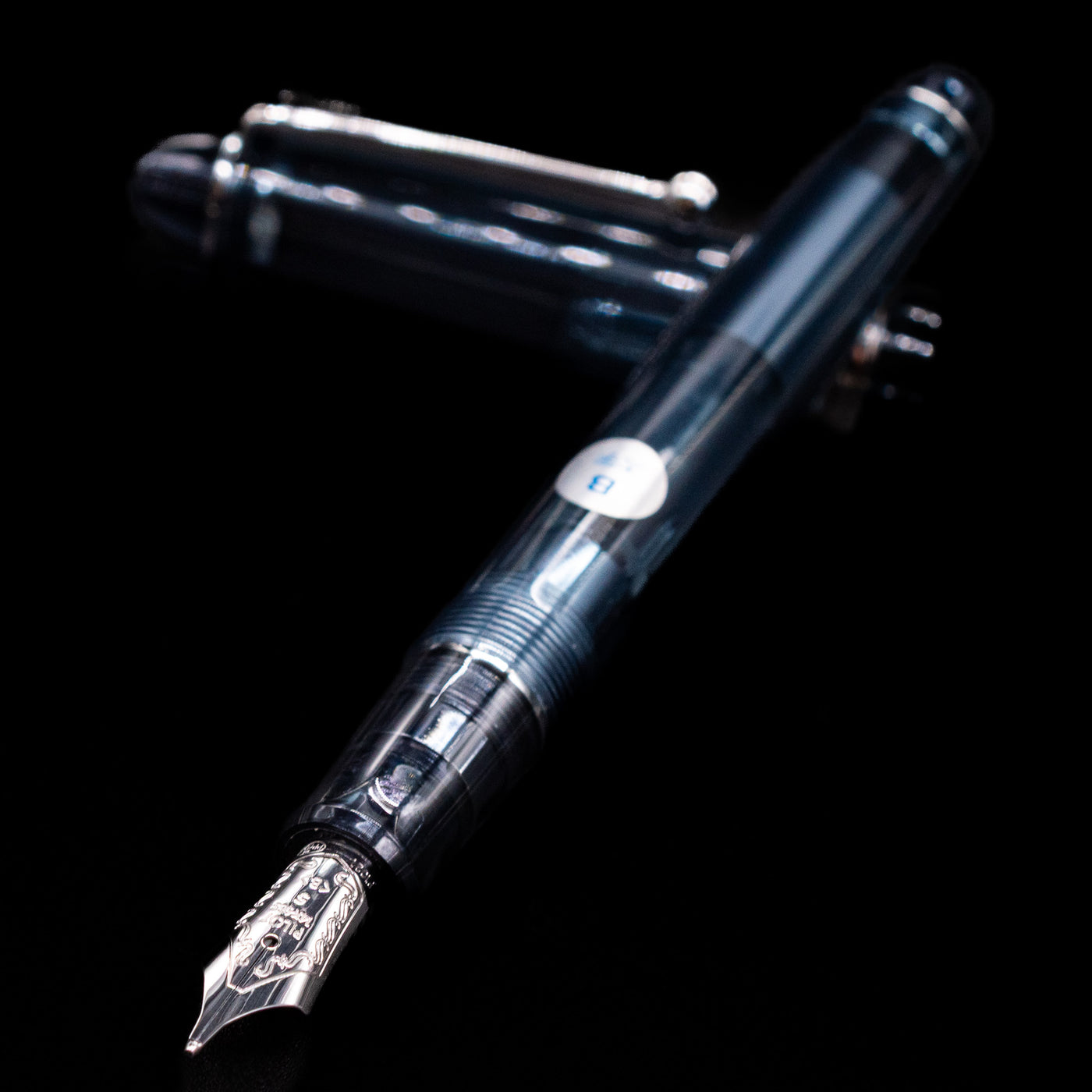 Pilot Custom 74 Fountain Pen - Blue Stone laying across its own cap, crossed, with a focus on the nib.