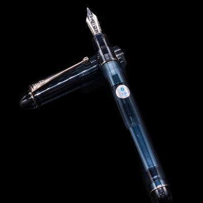 Pilot Custom 74 Fountain Pen - Blue Stone laying on top of its cap in a crossed position showing full view of the entire uncapped pen.