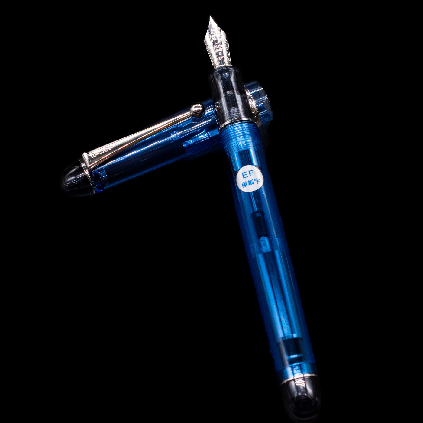 Pilot Custom 74 Fountain Pen - Blue laying on top of its cap in a crossed position showing full view of the entire uncapped pen.