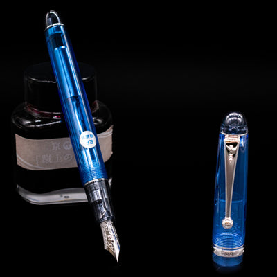 Pilot Custom 74 Fountain Pen - Blue leaning on an ink bottle uncapped showcasing the detailing on the nib.