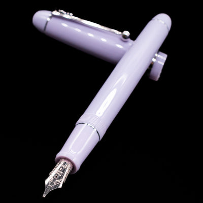 Pilot Custom 74 Fountain Pen - Lavender Fog laying across its own cap, crossed, with a focus on the nib.
