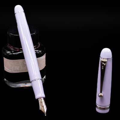 Pilot Custom 74 Fountain Pen - Lavender Fog leaning on an ink bottle uncapped showcasing the detailing on the nib.