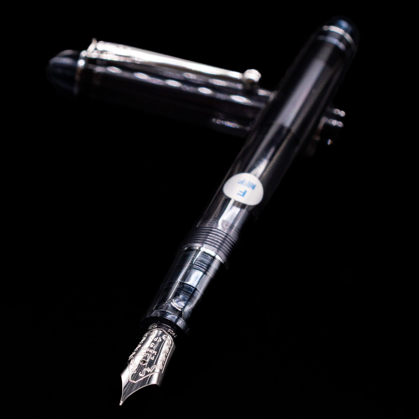 Pilot Custom 74 Fountain Pen - Smoke laying across its own cap, crossed, with a focus on the nib.