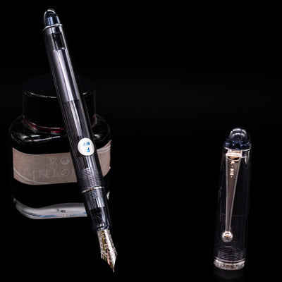 Pilot Custom 74 Fountain Pen - Smoke leaning on an ink bottle uncapped showcasing the detailing on the nib.