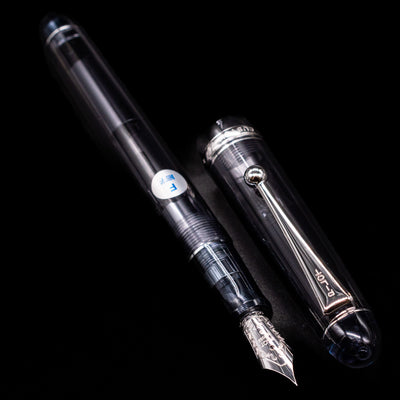 A full view of the Pilot Custom 74 Fountain Pen - Smoke uncapped, with its cap laying next to the pen. 