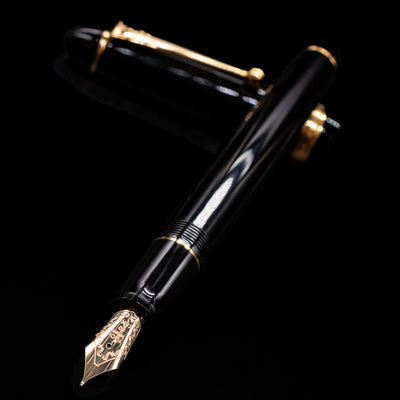 Pilot Custom 742 Black Fountain Pen - Preowned laying across its own cap, crossed, with a focus on the nib.