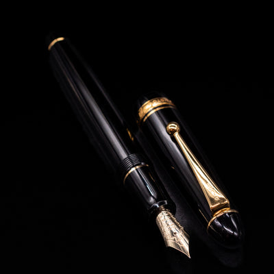 A full view of the Pilot Custom 742 Black Fountain Pen - Preowned uncapped, with its cap laying next to the pen. 
