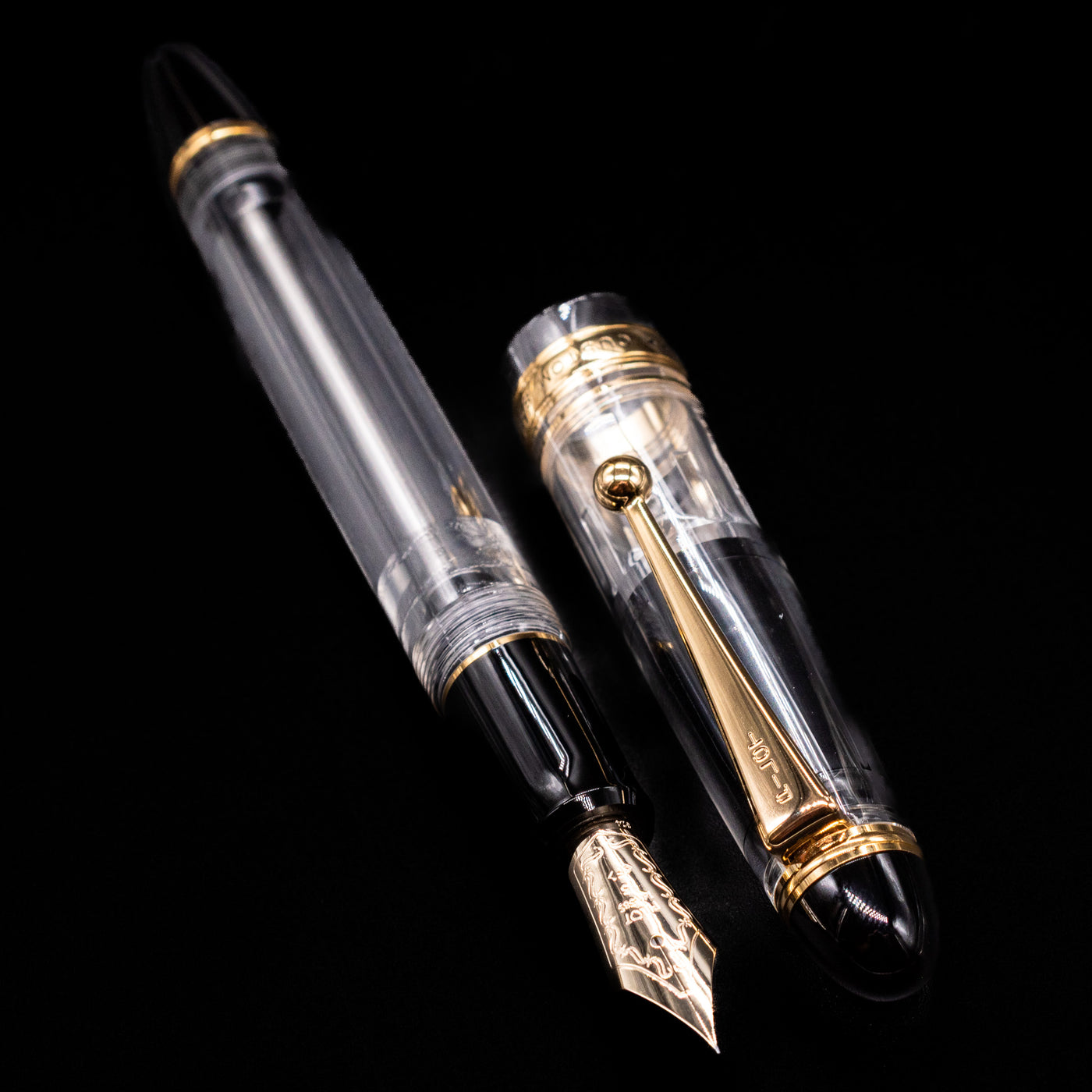 A full view of the Pilot Custom 823 Fountain Pen - Clear uncapped, with its cap laying next to the pen. 