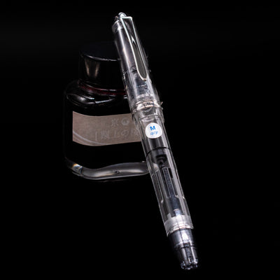 Pilot Custom Heritage 92 Fountain Pen - Clear capped, leaning against an ink bottle. 