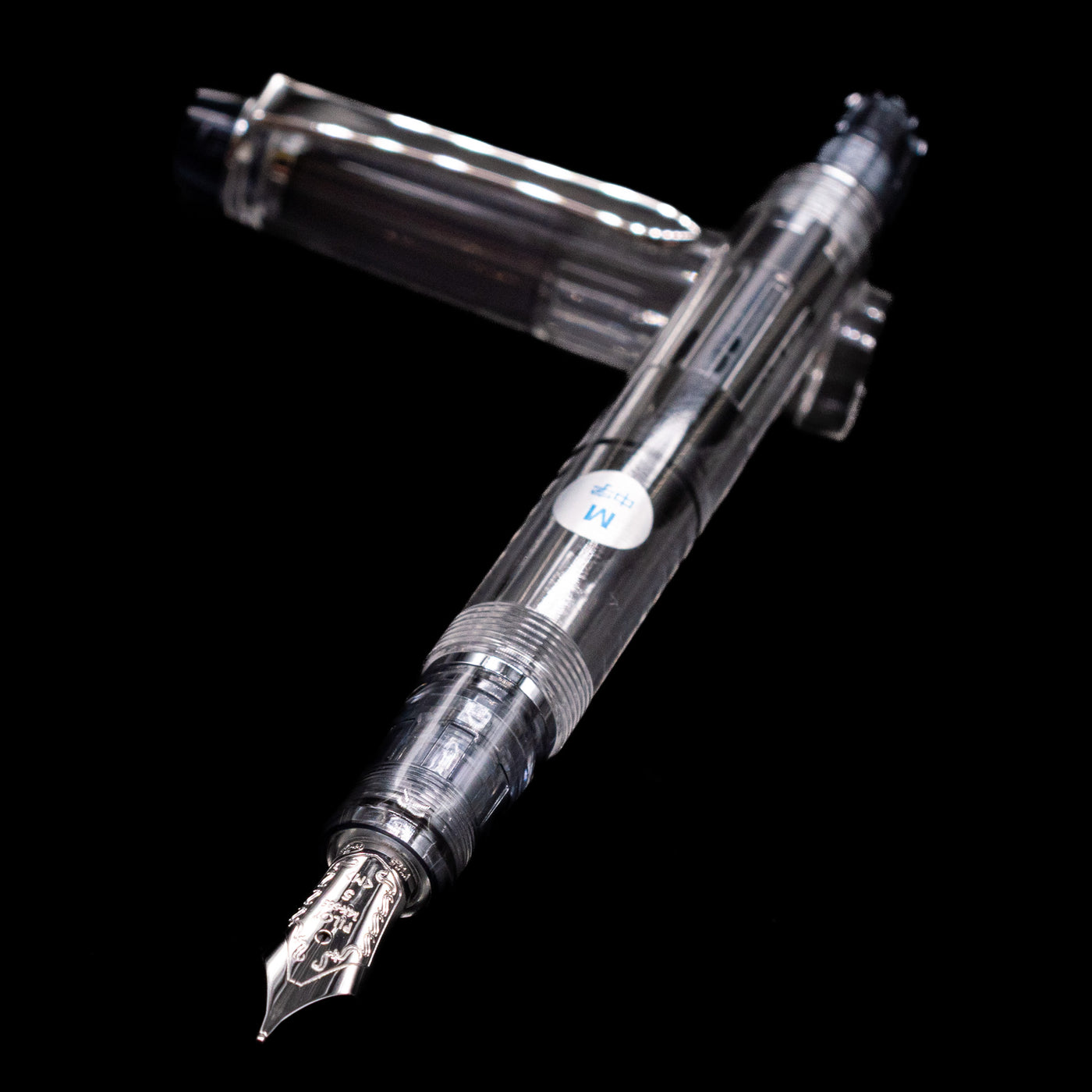 Pilot Custom Heritage 92 Fountain Pen - Clear laying across its own cap, crossed, with a focus on the nib.