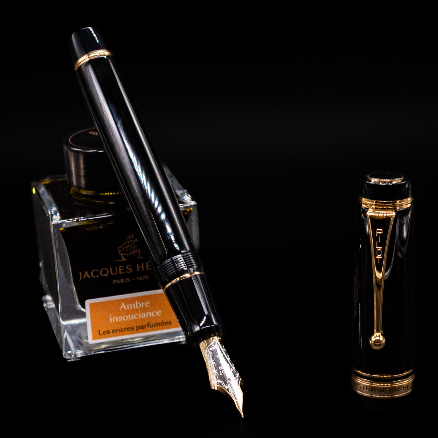 Pilot Custom Urushi Fountain Pen - Black leaning on an ink bottle uncapped showcasing the detailing on the nib.