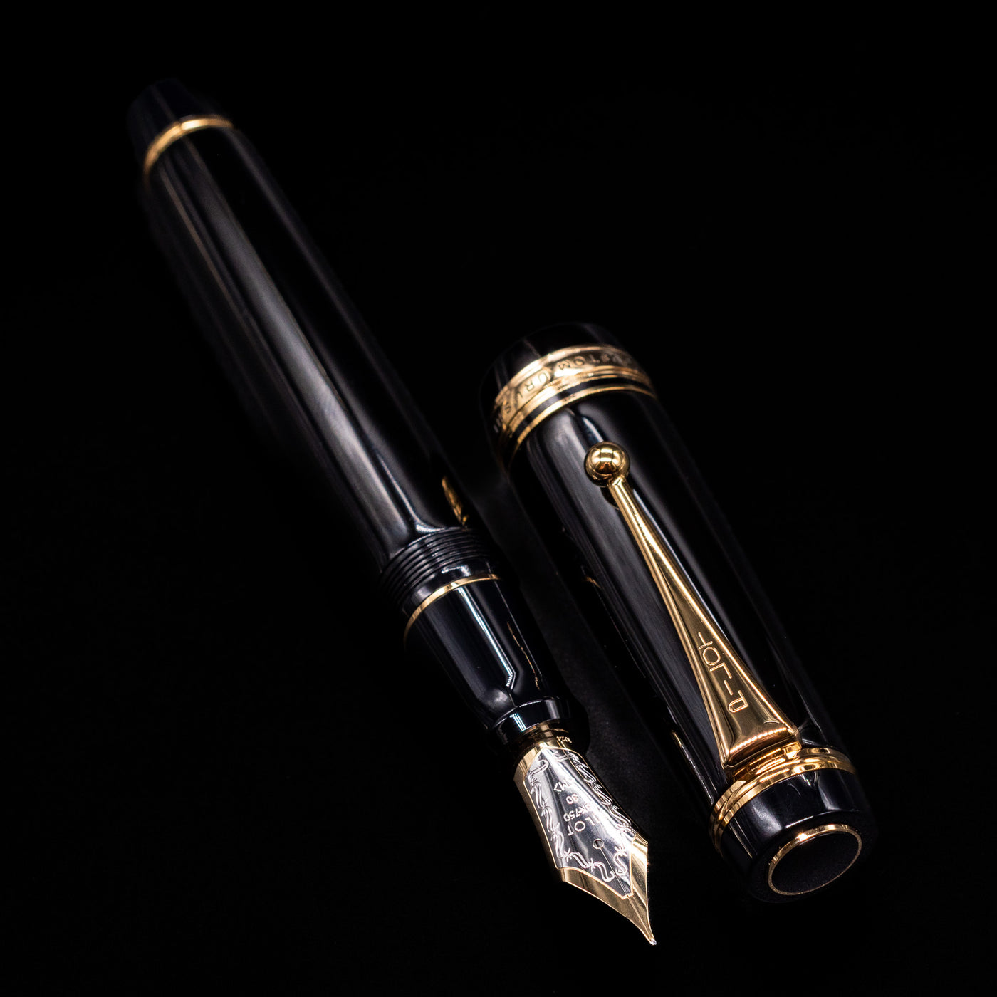 A full view of the Pilot Custom Urushi Fountain Pen - Black uncapped, with its cap laying next to the pen. 