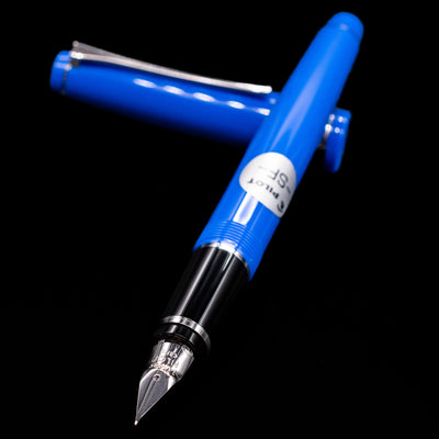 Pilot Falcon Fountain Pen - Blue laying across its own cap, crossed, with a focus on the nib.