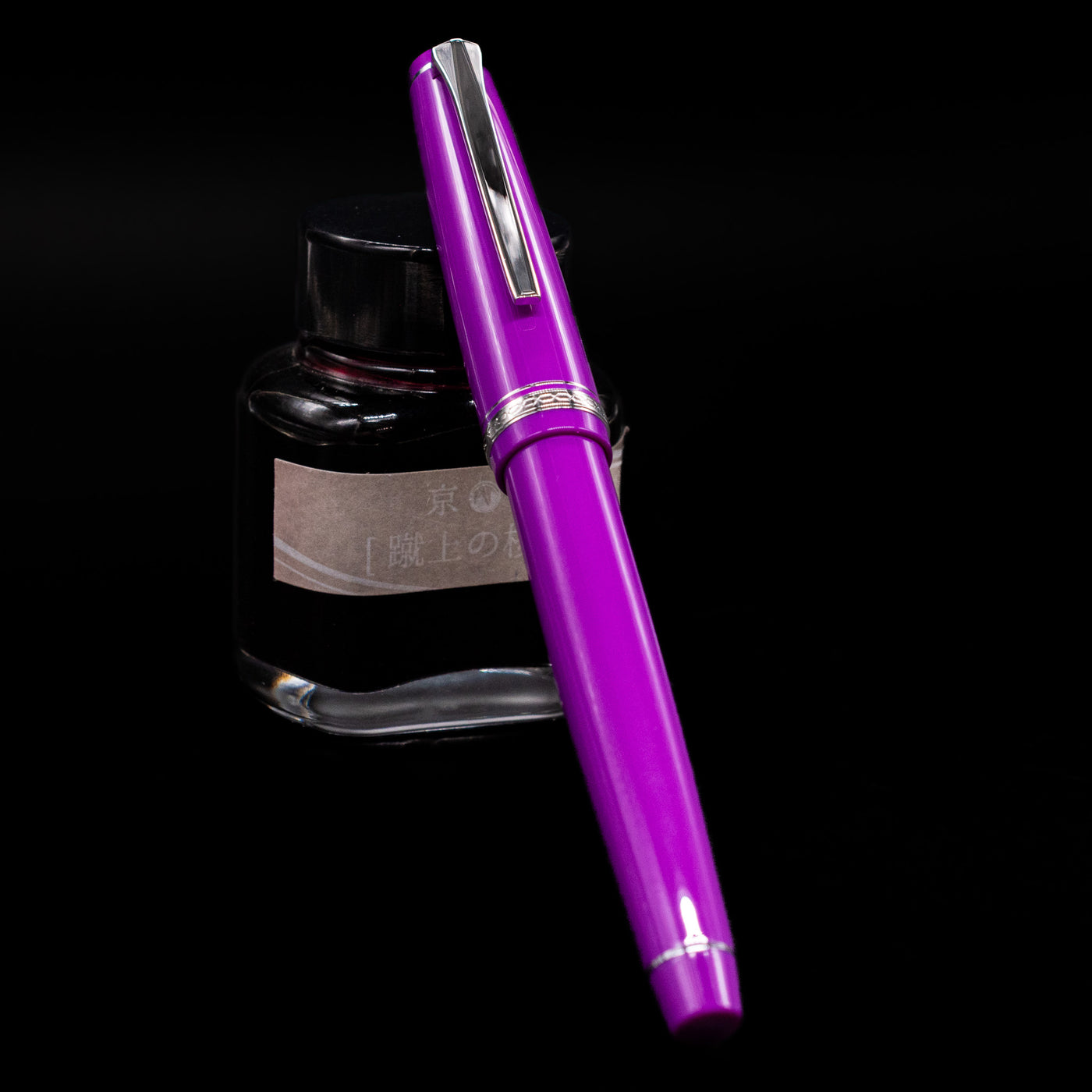 Pilot Falcon Fountain Pen - Purple capped, leaning against an ink bottle. 