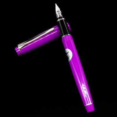 Pilot Falcon Fountain Pen - Purple laying on top of its cap in a crossed position showing full view of the entire uncapped pen.
