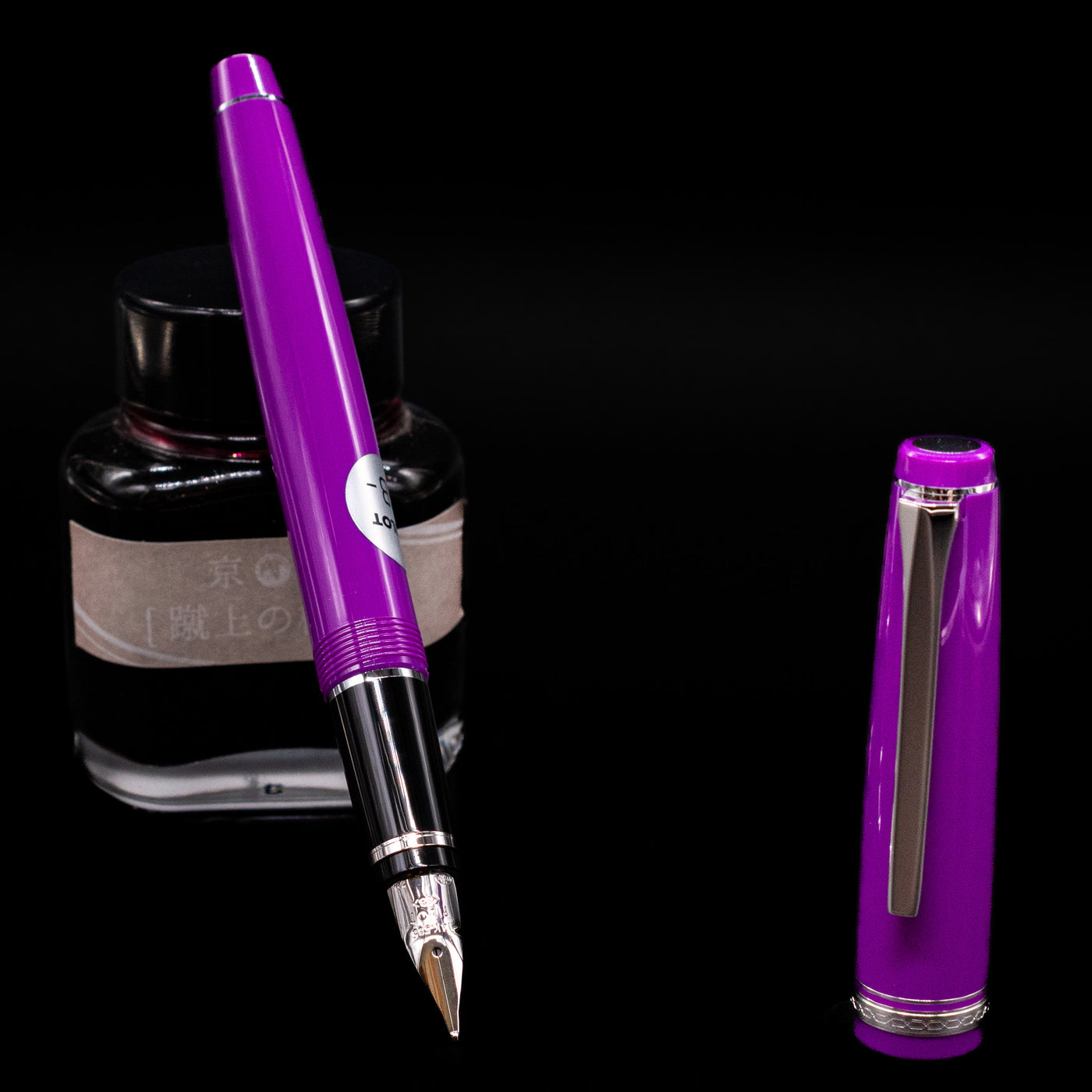Pilot Falcon Fountain Pen - Purple leaning on an ink bottle uncapped showcasing the detailing on the nib.