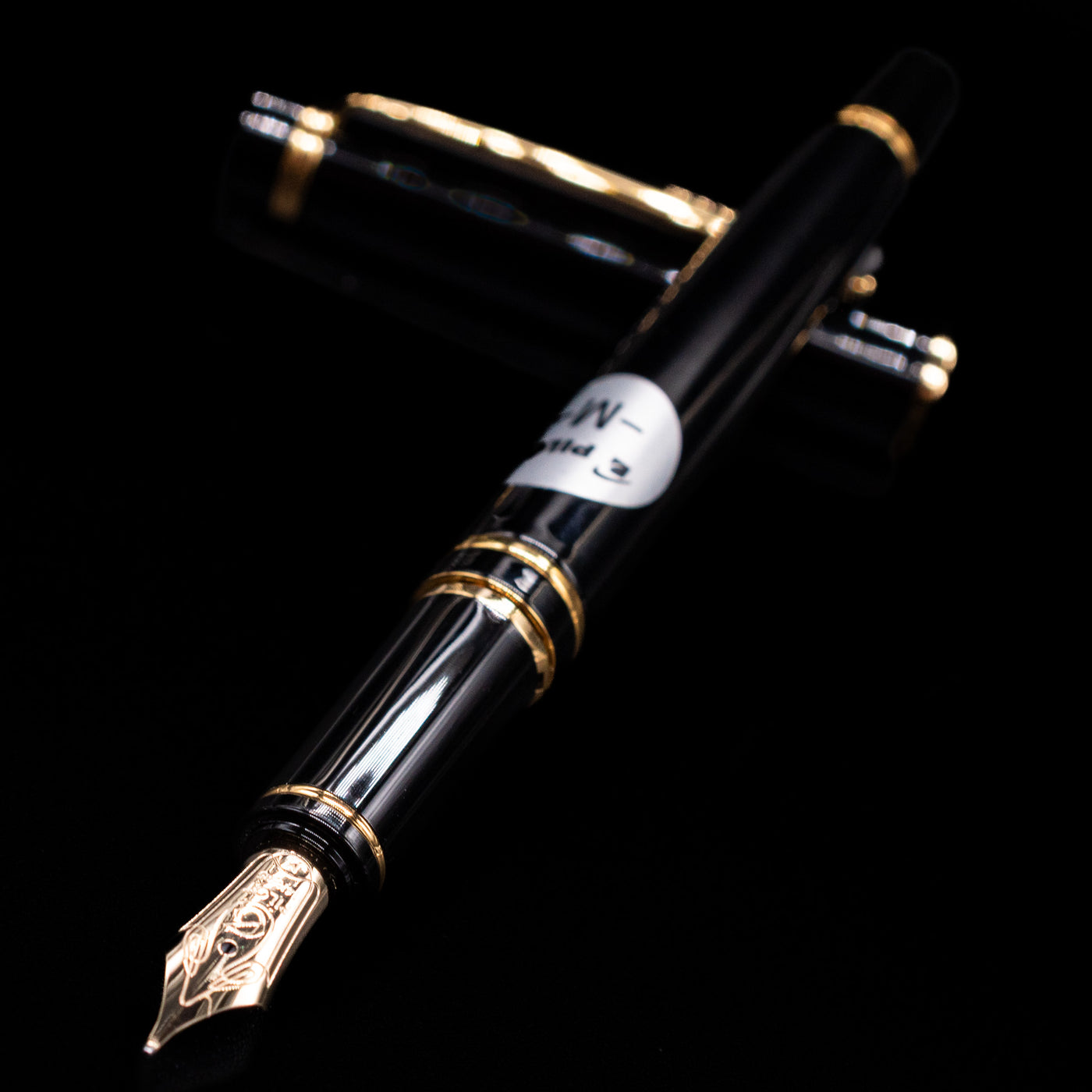 Pilot Grance Fountain Pen - Black laying across its own cap, crossed, with a focus on the nib.