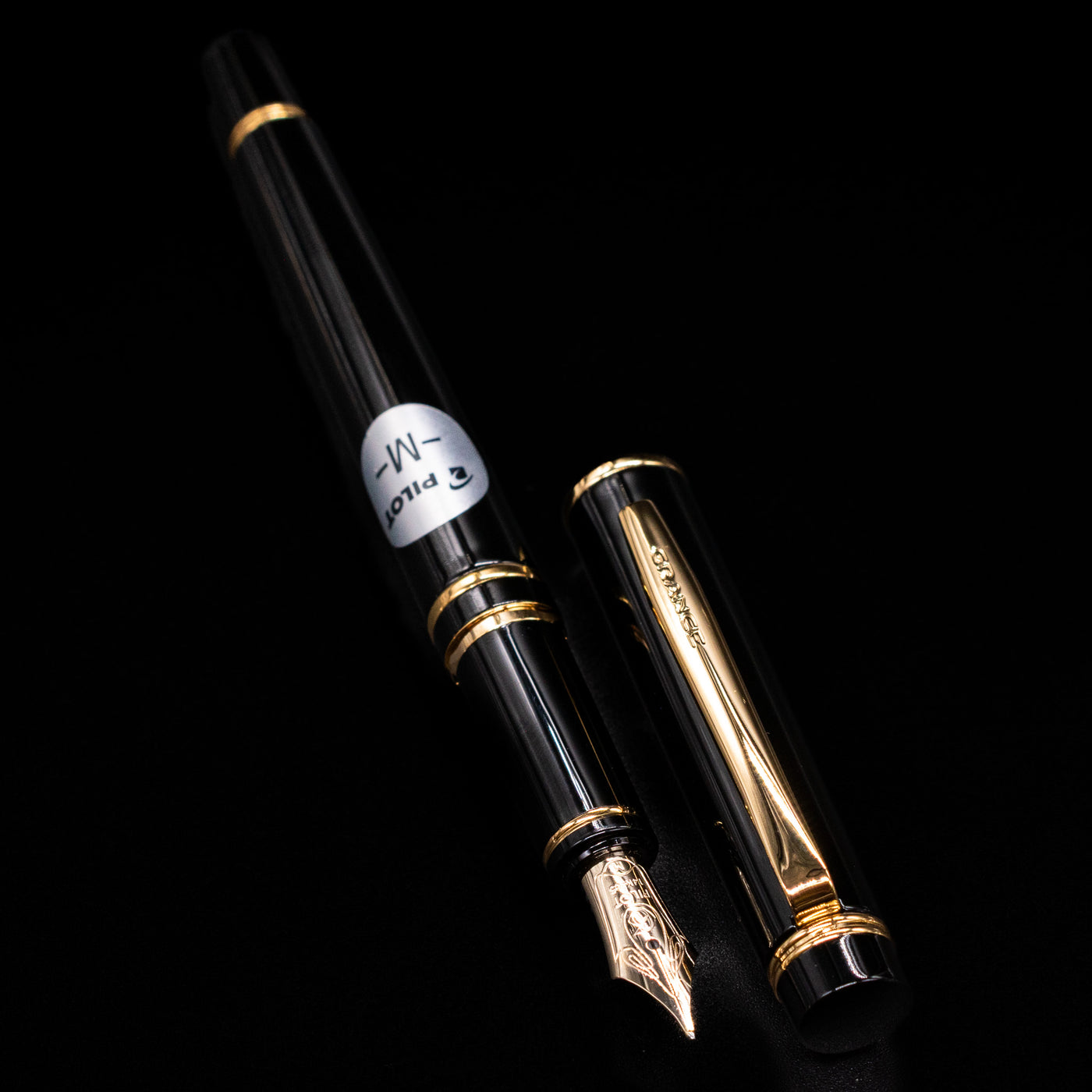 A full view of the Pilot Grance Fountain Pen - Black uncapped, with its cap laying next to the pen.