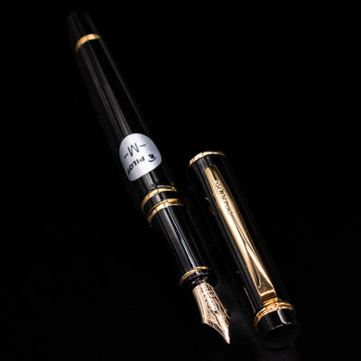 A full view of the Pilot Grance Fountain Pen - Black uncapped, with its cap laying next to the pen.