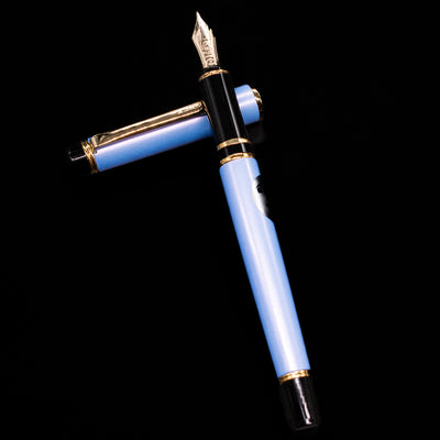 Pilot Grance Fountain Pen - Light Blue laying on top of its cap in a crossed position showing full view of the entire uncapped pen.