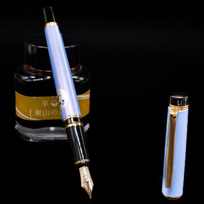 Pilot Grance Fountain Pen - Light Blue  leaning on an ink bottle uncapped showcasing the detailing on the nib.