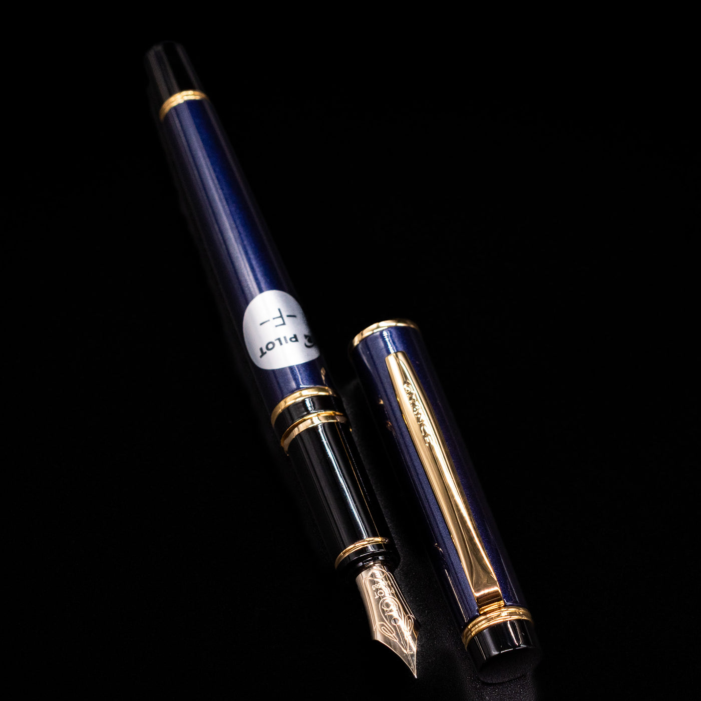 A full view of the Pilot Grance Fountain Pen - Navy Blue uncapped, with its cap laying next to the pen. 