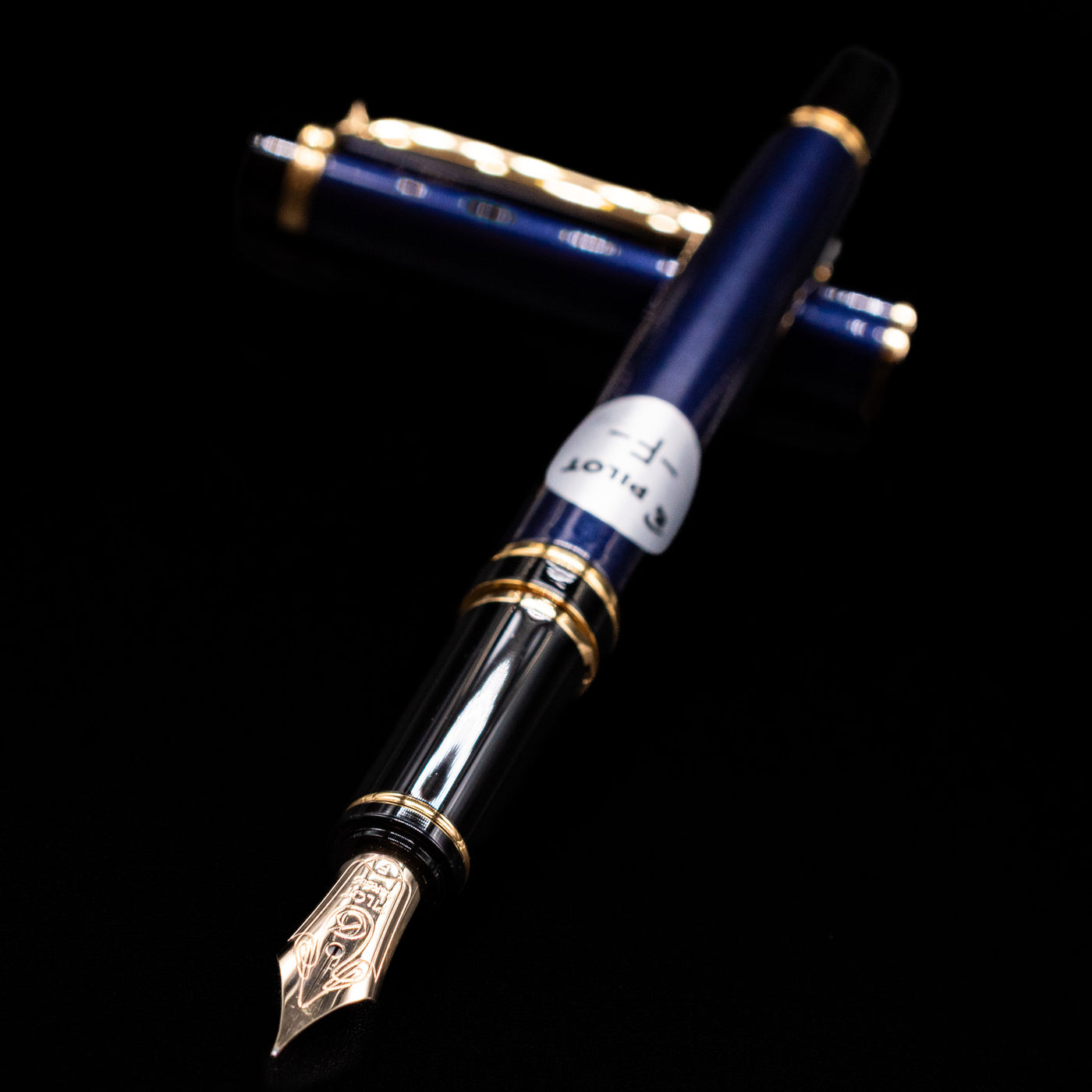 Pilot Grance Fountain Pen - Navy Blue laying across its own cap, crossed, with a focus on the nib.