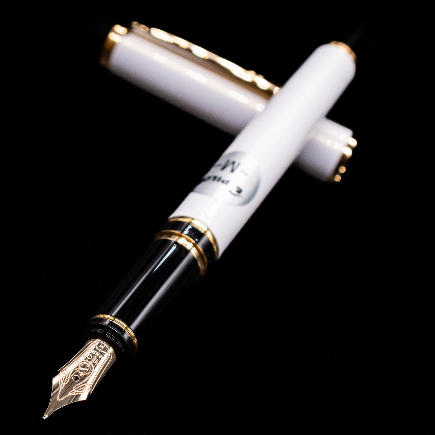 Pilot Grance Fountain Pen - Pearl White laying across its own cap, crossed, with a focus on the nib.