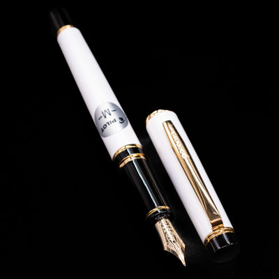  A full view of thePilot Grance Fountain Pen - Pearl White uncapped, with its cap laying next to the pen. 